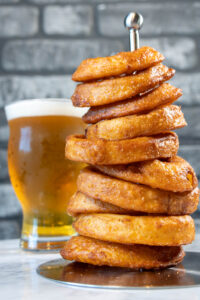 Stack of onion rings with glass of beer