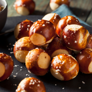 Stack of round pretzel bites with salt on a black slate plate