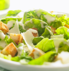 Ceasar Salad with green lettuce parmasan slices and croutons